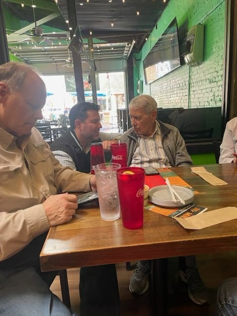 Dr. Brent Steele discussing hearing aid performance with patients at a restaurant table