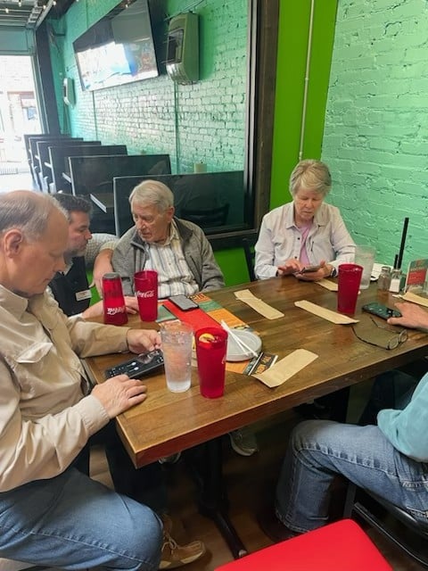 The Hearing Guy patients testing hearing aids together in a busy Asheville restaurant