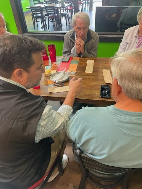 Dr. Brent Steele working with patients in a restaurant as part of Experience Hearing real world fitting care