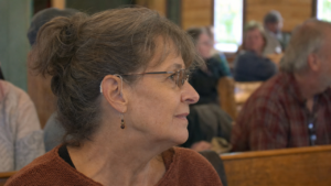 Woman using an assistive listening system during a community gathering